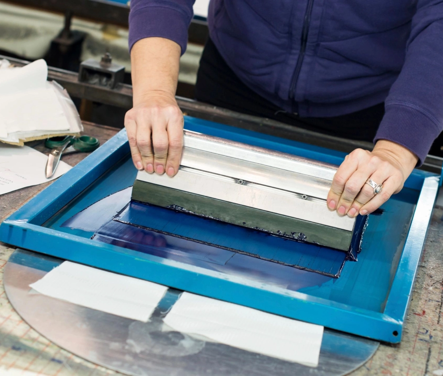 A person using a screen printing machine