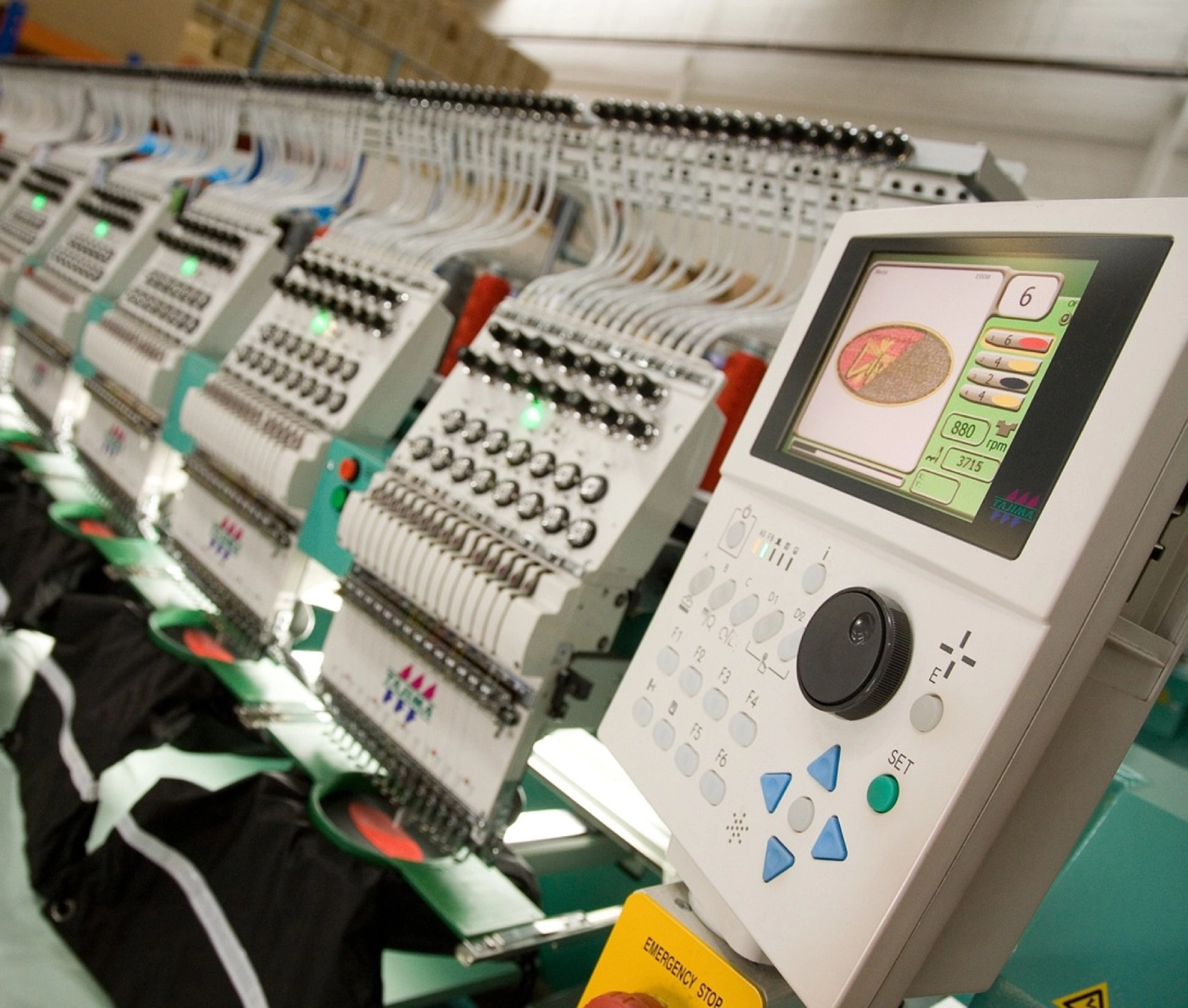 A row of embroidery machines in a shop.