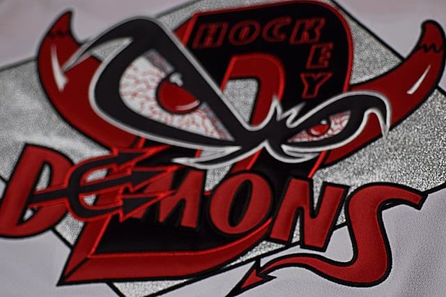 A close up of the words " hockey " and " demons ".